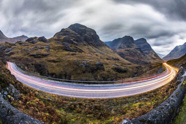 UK, Scotland, car light trails on scenic road through the mountains in the Scottish highlands near Glencoe at dusk - WPEF00686