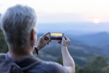 Spanien, Katalonien, Mann beim Fotografieren des Montserrat bei Sonnenuntergang - AFVF00802