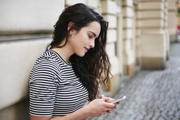 Junge Frau beim Telefonieren in der Stadt - ABIF00679