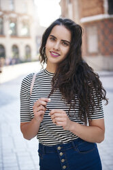 Portrait of smiling young woman in the city - ABIF00687