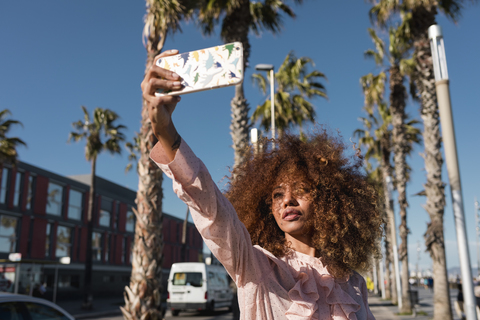 Stylish young woman taking a selfie at seaside promenade stock photo