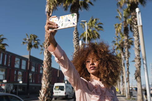 Stylish young woman taking a selfie at seaside promenade - MAUF01511