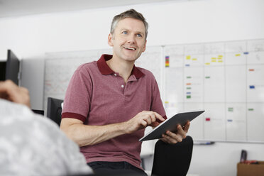 Man sitting in office using digital tablet - CUF42964