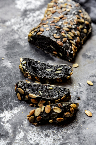 Schwarzes Sepiadinkelbrot mit Kürbiskernen, lizenzfreies Stockfoto