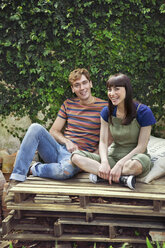 Ehepaar auf Holzpaletten sitzend - CUF43094