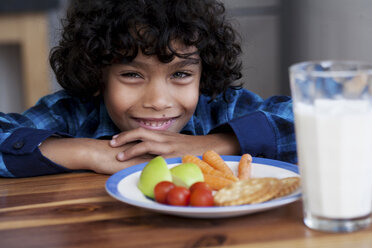 Boy smiling with snacks and glass of milk - CUF43229