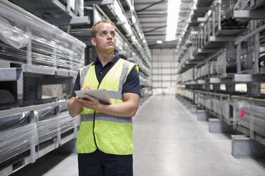 Worker checking order in engineering warehouse - CUF43408