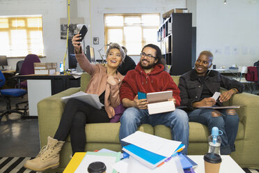 Glückliche kreative Geschäftsleute machen ein Selfie in einem lässigen Großraumbüro - CAIF21002