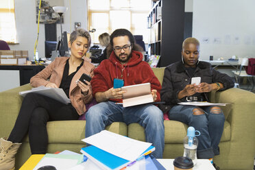 Kreative Geschäftsleute, die Smartphones benutzen und sich in einem lockeren Büro treffen - CAIF21004