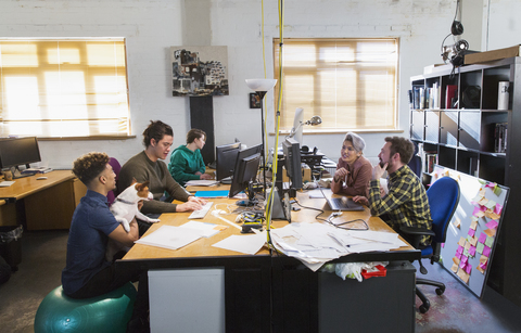 Kreative Geschäftsleute bei der Arbeit, Treffen an Computern in einem Großraumbüro, lizenzfreies Stockfoto