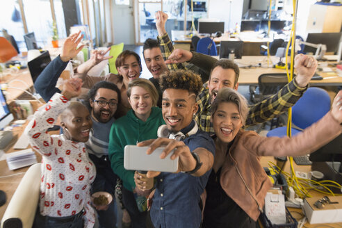 Enthusiastisches Kreativteam jubelt und macht ein Selfie im Büro - CAIF21036