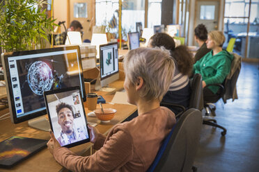 Kreative Geschäftsfrau im Videochat mit Geschäftsmann auf digitalem Tablet in Großraumbüro - CAIF21038