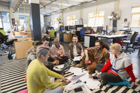 Treffen des Kreativteams, Brainstorming auf dem Boden im Büro, lizenzfreies Stockfoto