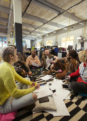 Creative business team meeting, brainstorming in circle on office floor - CAIF21086