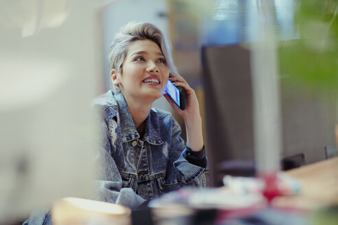 Kreative Geschäftsfrau im Gespräch mit einem Smartphone - CAIF21100
