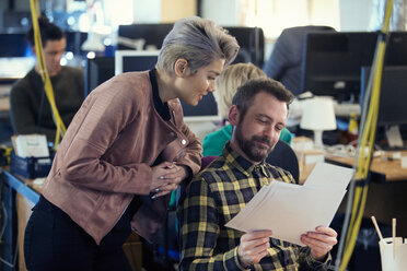 Kreative Geschäftsleute, die im Büro Papierkram besprechen - CAIF21105