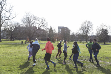 Läufer joggen im Kreis in einem sonnigen Park - CAIF21118