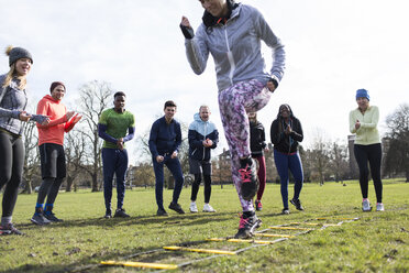 Team jubelnde Frau beim Speed Ladder Drill im sonnigen Park - CAIF21122