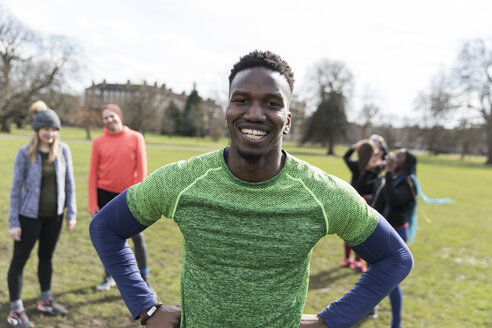 Porträt lächelnder, selbstbewusster männlicher Läufer im sonnigen Park - CAIF21144