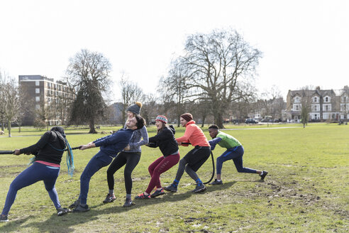 Entschlossenes Team zieht beim Tauziehen im Park am Seil - CAIF21162