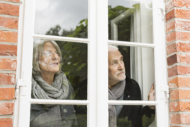 Senior couple looking through window - CUF43486