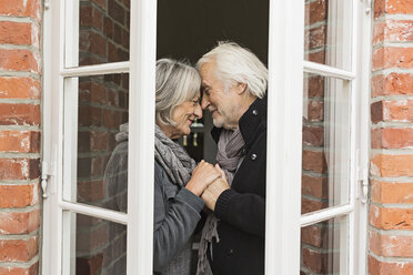 Senior couple face to face by window - CUF43487