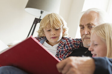Großvater liest den Enkeln ein Buch vor - CUF43492