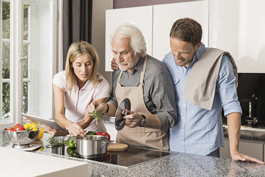 Älterer Mann mit erwachsenem Paar bei der Essenszubereitung - CUF43508