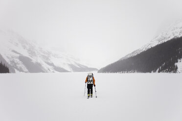 Ein Skifahrer überquert einen zugefrorenen See auf der Wapta Traverse, einer Skitour von Hütte zu Hütte in Alberta, Kanada. - MINF00031