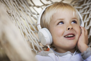 A young boy lying in a hammock wearing music headphones. - MINF00056