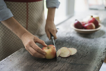 Eine Person schneidet einen Bio-Apfel auf. - MINF00066