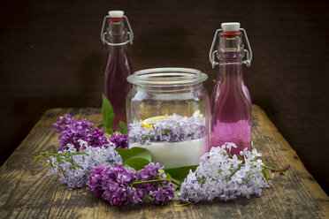 Glass bottles of homemade lilac sirup and ingredients in glass - LVF07303