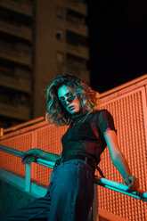 Stylish young woman at night in the city, wearing sunglasses - KKAF01233