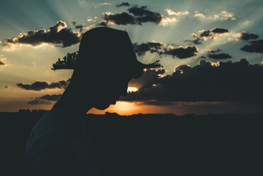 Silhouette eines jungen Mannes mit Hut bei Sonnenuntergang - ACPF00144