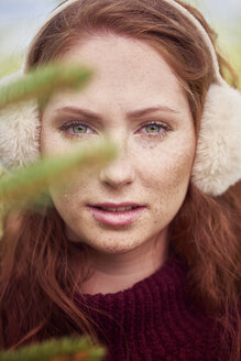 Porträt einer rothaarigen jungen Frau mit Sommersprossen, die einen Ohrenschützer trägt - ABIF00702
