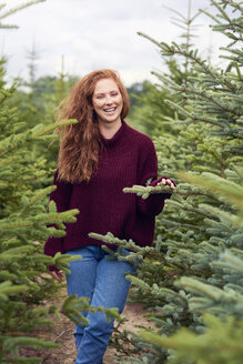 Porträt einer lachenden rothaarigen jungen Frau im Wald - ABIF00709