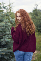 Portrait of smiling redheaded young woman in the woods - ABIF00710