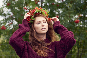 Portrait of redheaded young woman wearing wreath of rowanberries - ABIF00714