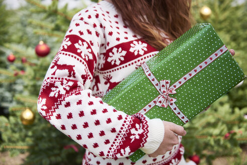 Woman holding Christmas present, partial view - ABIF00719