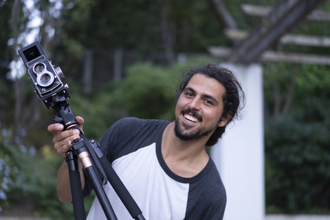 Portrait of happy young man with vintage camera stock photo