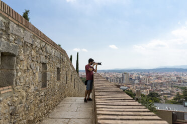 Spanien, Girona, Mann an der Gießkanne beim Fotografieren der Stadt - AFVF00813