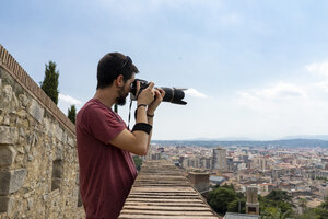 Spanien, Girona, Mann an der Gießkanne beim Fotografieren der Stadt - AFVF00815