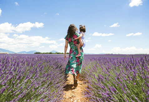 Frankreich, Provence, Hochebene von Valensole, Mutter und Tochter spazieren zwischen Lavendelfeldern im Sommer - GEMF02119