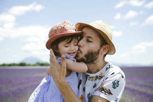 Frankreich, Provence, Hochebene von Valensole, Vater küsst Tochter in Lavendelfeldern im Sommer - GEMF02127