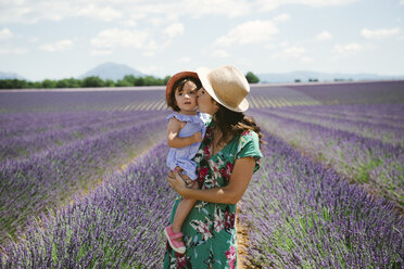 Frankreich, Provence, Hochebene von Valensole, Mutter küsst Tochter in Lavendelfeldern im Sommer - GEMF02145