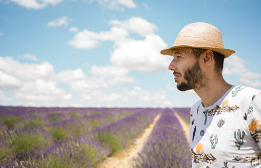 Frankreich, Provence, Hochebene von Valensole, Mann mit Strohhut in Lavendelfeldern im Sommer - GEMF02157