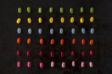 Arrangement of colorful candies on black ground - AFVF00824