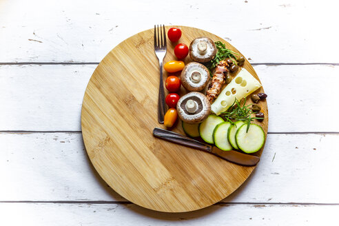 Vegetables on round chopping board, symbol for intermittent fasting - SARF03857