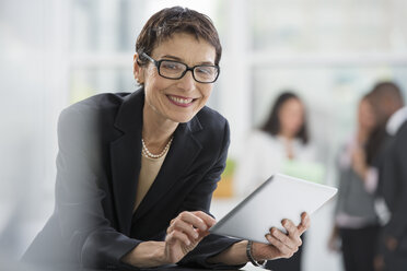 An office interior. A woman in a black jacket using a digital tablet. - MINF00092