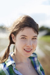 A young woman with braids wearing a green and blue plaid shirt. - MINF00110